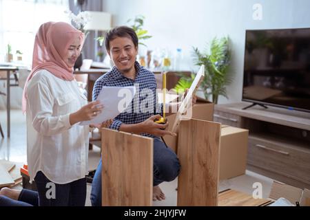 Young muslim couple assembling furniture at home Stock Photo