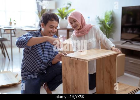 Young muslim couple assembling furniture at home Stock Photo
