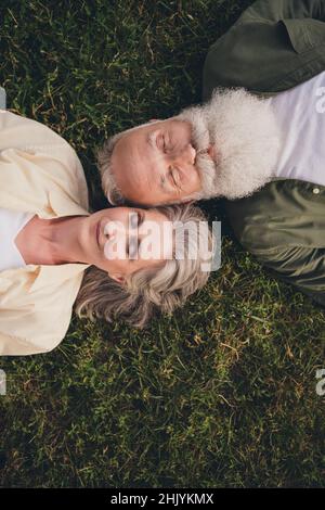 Vertival photo of rest pensioner grey hair couple wear trend shirts outside spend free time Stock Photo