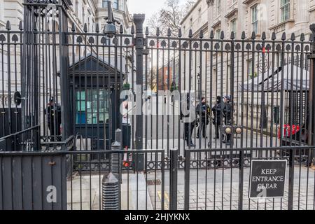 Downing Street, London. Armed and uniformed London Metropolitan police officers standing guard at the gates of the residence of the UK Prime Minister. Stock Photo