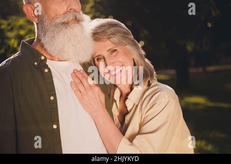 Cropped photo of cute emotion aged grey hair couple hug wear shirts outside spend free time Stock Photo