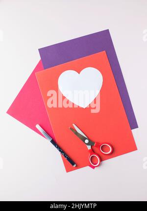 Colored paper, scissors and a heart-shaped blank to create a gift card with your own hands. Stock Photo