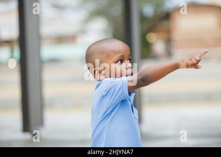 A little boy standing outside and pointing Stock Photo