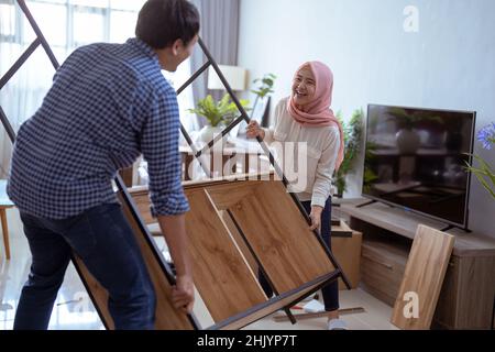 couple carrying new furniture together at their house Stock Photo