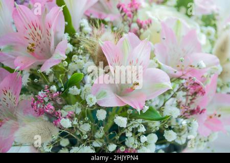 Close-up of delicate flowers of pink lilies, white roses, gypsophila. Floral background. Copy space. Stock Photo