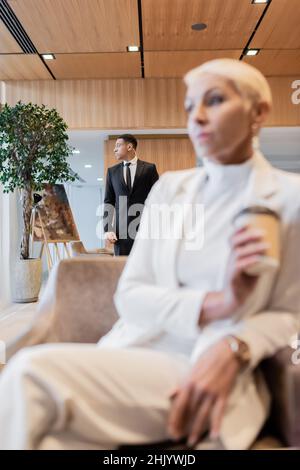 selective focus of african american bodyguard near senior business lady on blurred foreground Stock Photo