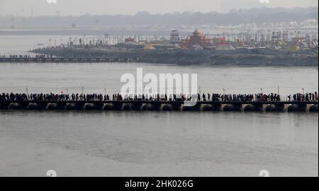 Devotees cross the River Ganges from a pontoon bridge during the ongoing Magh Mela at the bank of River Ganges in Prayagraj, India. Stock Photo