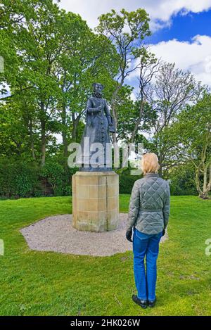 Linlithgow  palace, grounds.  Visitor, Tourist, looking at statue of Mary Queen of Scots, birthplace, West Lothian, Central Scotland, uk Stock Photo