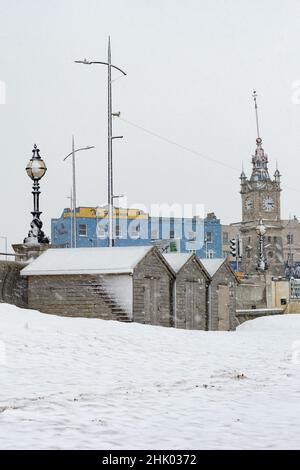 Beach huts and the Clock Tower in the snow, Margate, Kent Stock Photo