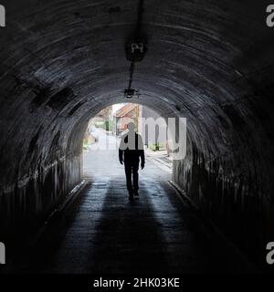 Vertrijk, Boutersem, Flemish Brabant Region, Belgium - 01 29 2022: Man walking in the narrow tunnel down the railway tracks
