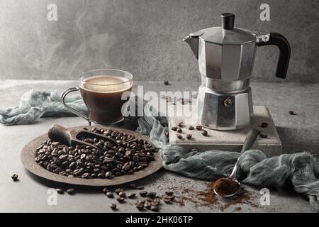 Hot coffee in a glass cup and coffee beans on a light background. Stock Photo