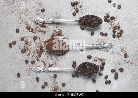 Top view of three spoons with coffee and coffee beans on light background. Flat lay composition. Stock Photo