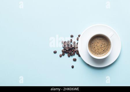 White coffee cup with coffee beans isolated  on light blue background with copy space. Stock Photo