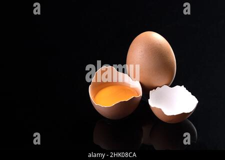 Egg and broken chicken egg isolated on black background with copyspace. Stock Photo