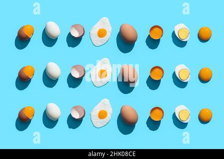 Flat Lay Composition with eggs cooked in different ways on blue background. Stock Photo