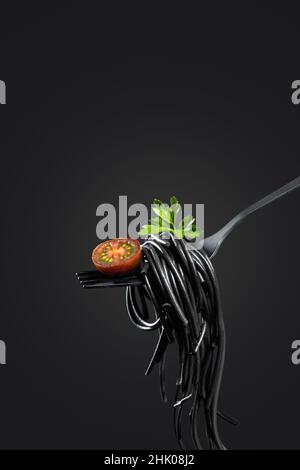 Black pasta rolled on a fork isolated on black background   with copyspace. Vertical format. Cooking concept. Stock Photo