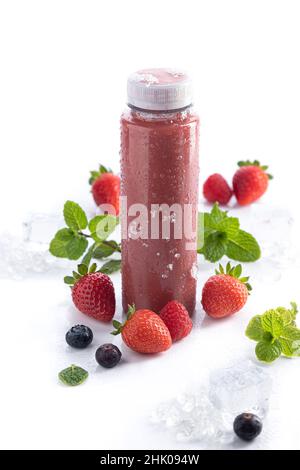 Strawberry smoothie bottle with detox superfood on white background and copy space. Vertical format. Healthy drinks concept. Stock Photo