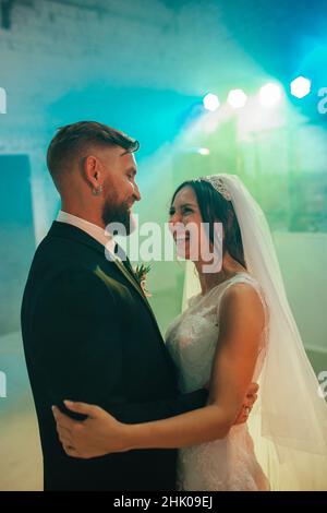 Wedding bride and groom dancing the first dance in the restaurant. smile and look at each other Yaremche, Bukovel, Ukraine - January 10, 2022 Stock Photo