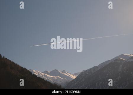 Mountain of Kackar and mountain peak covered by snow at winter season and airplane trace on sky above summit of peak.. Stock Photo
