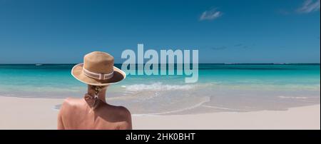 Woman with summer hat relaxing on the beach. Stock Photo