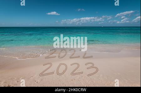 Text Happy New Year 2023 on the snow. Handwritten inscription 2023 and traces of the coming year