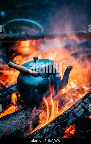 Camping kettle over burning campfire Stock Photo - Alamy