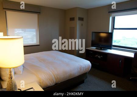 CHICAGO, ILLINOIS, UNITED STATES - MAY 11, 2018: KIng-size hotel bed in luxury hotel overlooking Lake Michigan Stock Photo