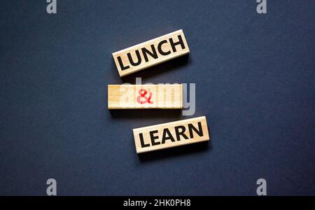 Lunch and learn symbol. Concept words Lunch and learn on wooden blocks. Beautiful black table black background. Copy space. Business, educational and Stock Photo