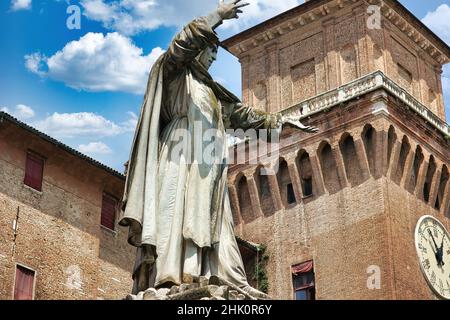 Monument to Girolamo Savonarola and in the background the Marchesana tower of the Estense Castle in Ferrara Stock Photo