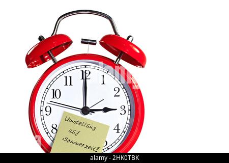 Alarm clock with sticky note and the note "Umstellung auf Sommerzeit", translation "Daylight Saving Time" Stock Photo