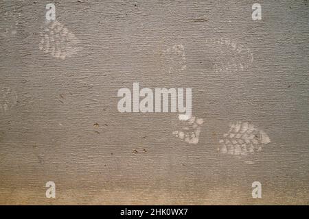 Work boots footprints on gray plastered wall, grunge texture or background Stock Photo