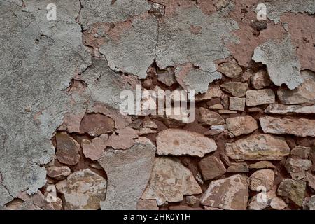 Old traditional limewashed stone wall with peeling plaster, white rustic background or texture Stock Photo
