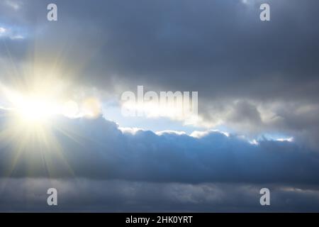 Rays of light shining through dark clouds, dramatic sky with cloud Stock Photo