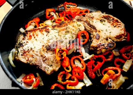 Cooked Pork Chops in a Pan with Onion and Mini Sweet Peppers Stock Photo