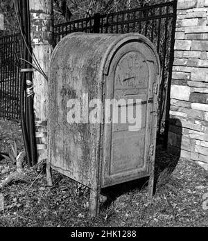 An old rusted,weathered,mailbox,in black and white. This is also called a dropbox for mail carriers to pick up mail to be delivered. Stock Photo