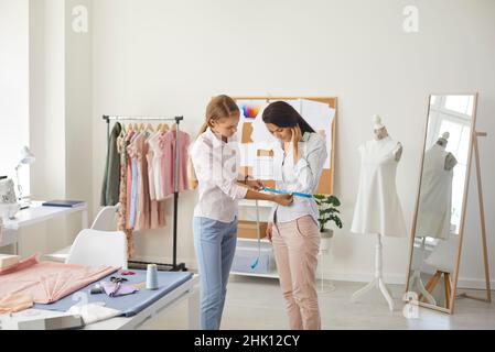 Woman tailor work with client in atelier Stock Photo