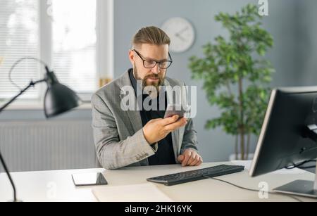 Man using smartphone at office Stock Photo