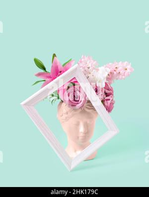 Collage with plaster antique sculpture of human face in a pop art style. Creative concept colorful neon ancient statue head, hair made of fresh flower Stock Photo