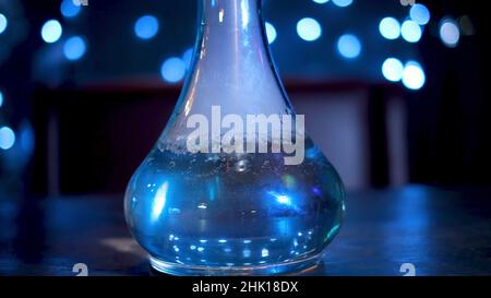 Bubbling water in hookah. Media. Drawing hookah with bubbling blue water and exhaling smoke. Hookah bowl with boiling water on background of blue ligh Stock Photo