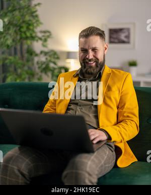 Man using laptop on couch Stock Photo