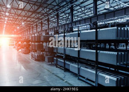 Metal profiled parts in packs on the shelves in warehouse. Stock Photo