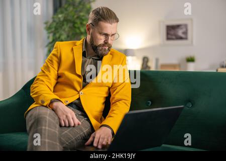 Man using laptop on sofa Stock Photo