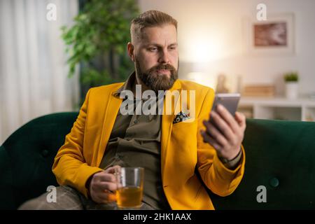 Man on couch with smartphone Stock Photo