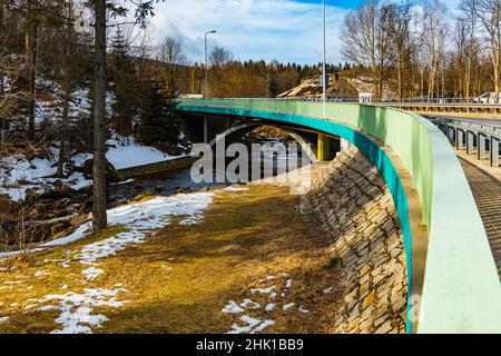 Giant Mountains, Poland - March 2021: Long small bridge over Kamienna river at winter Stock Photo