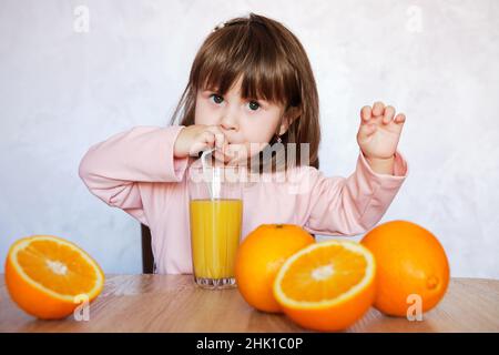 Cute baby girl drinking glass of fresh orange juice indoors. Healthy lifestyle Stock Photo Alamy