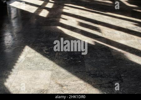 Shadows from window frames on stone indoor floor, shallow depth of field photo Stock Photo