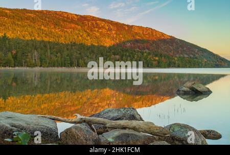 bright Autumn foliage reflected on the still waters of Jordon's pond Stock Photo