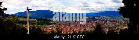 Panorama of mountains and town of Quetzaltenango with cross at top of lookout in Guatemala. Stock Photo
