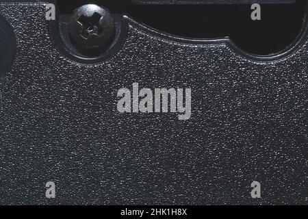 Black plastic surface with screw. detail of plastic cassette close up Stock Photo