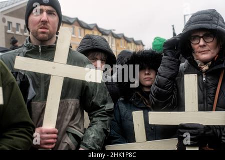 Derry, UK. 30th Jan, 2022. Four people carrying crosses gather for the remembrance walk to honor the victims.On January 30, 1972, the British Army's Parachute Regiment shot and killed 14 civilians. Victims' families, locals, supporters, and politicians commemorate the 50th anniversary of Bloody Sunday in Derry. The Prime Minister of Ireland, MicheÃl Martin, Member of Parliament Mary Lou McDonald, and Simon Coveney, Minister for Foreign Affairs of Ireland, all attended this year's event. (Credit Image: © Natalia Campos/SOPA Images via ZUMA Press Wire) Stock Photo